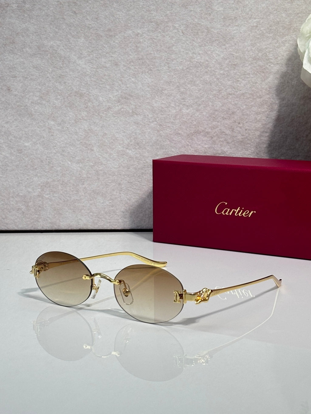 Round light-tinted sunglasses with gold-tone metal frames and slim gold temples