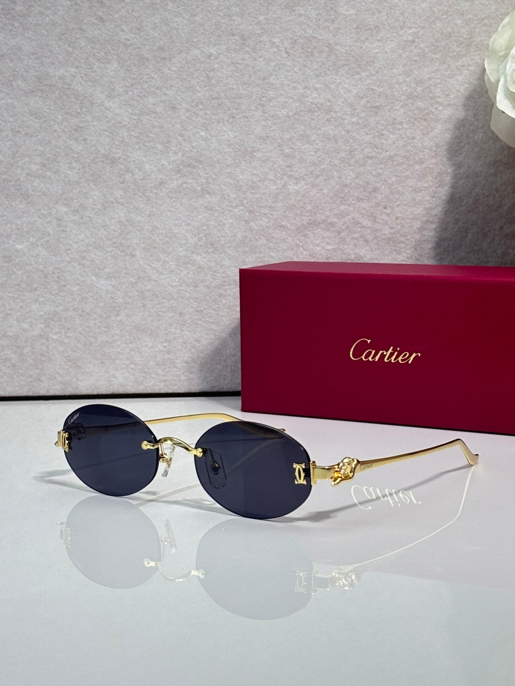 Round dark-tinted sunglasses with gold-tone metal frames and thin gold temples