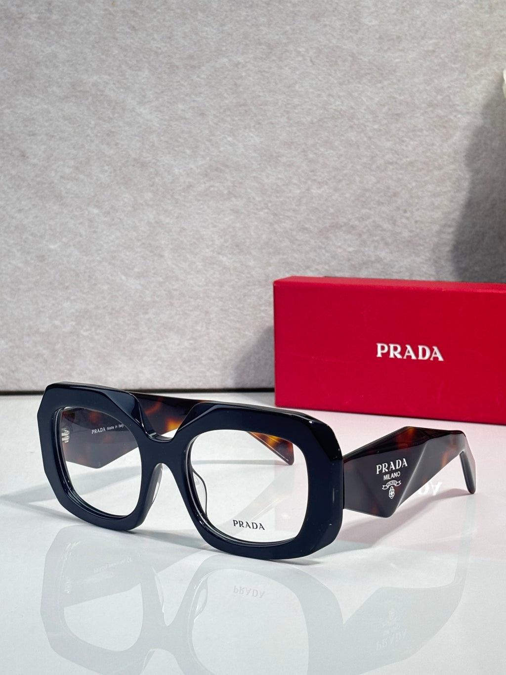 Prada eyeglasses with dark blue frames and clear lenses, angled side view