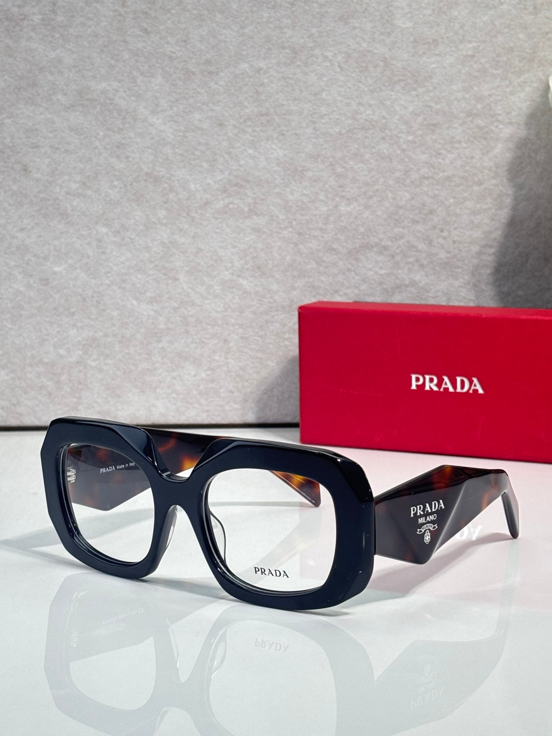 Prada eyeglasses with dark blue frames and clear lenses, angled side view