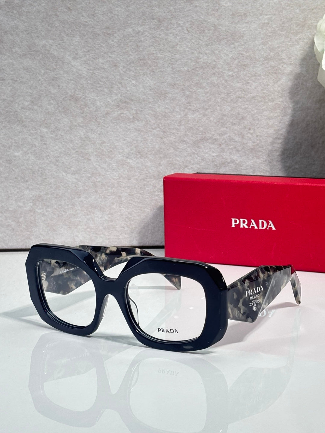 Prada eyeglasses with dark blue frames and clear lenses, logo on temple