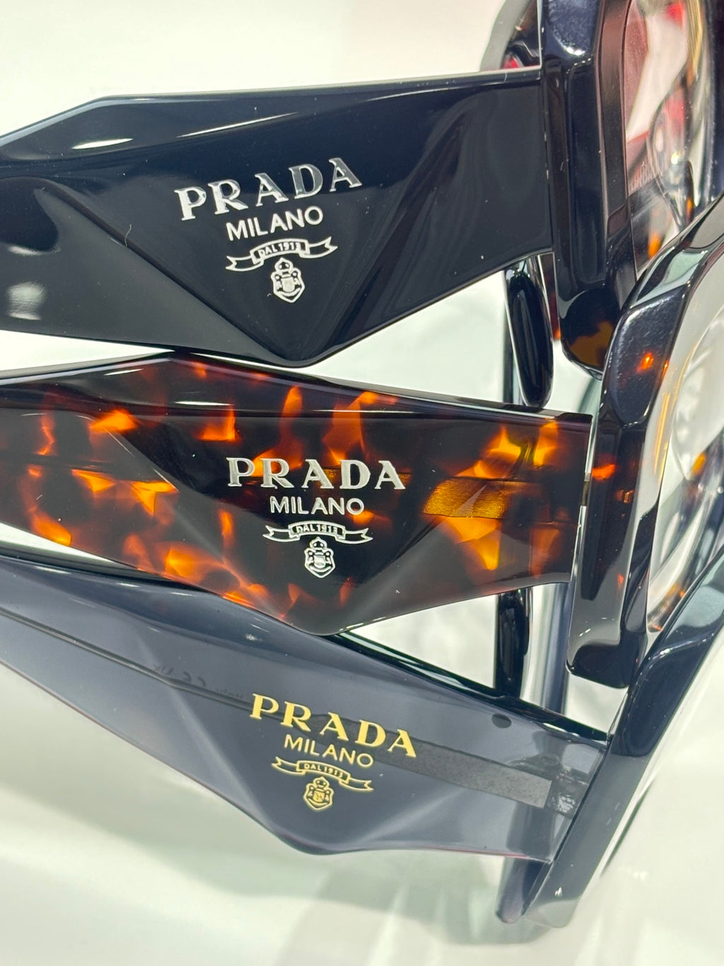 Prada eyeglasses temple close-up with PRADA MILANO branding on dark frames