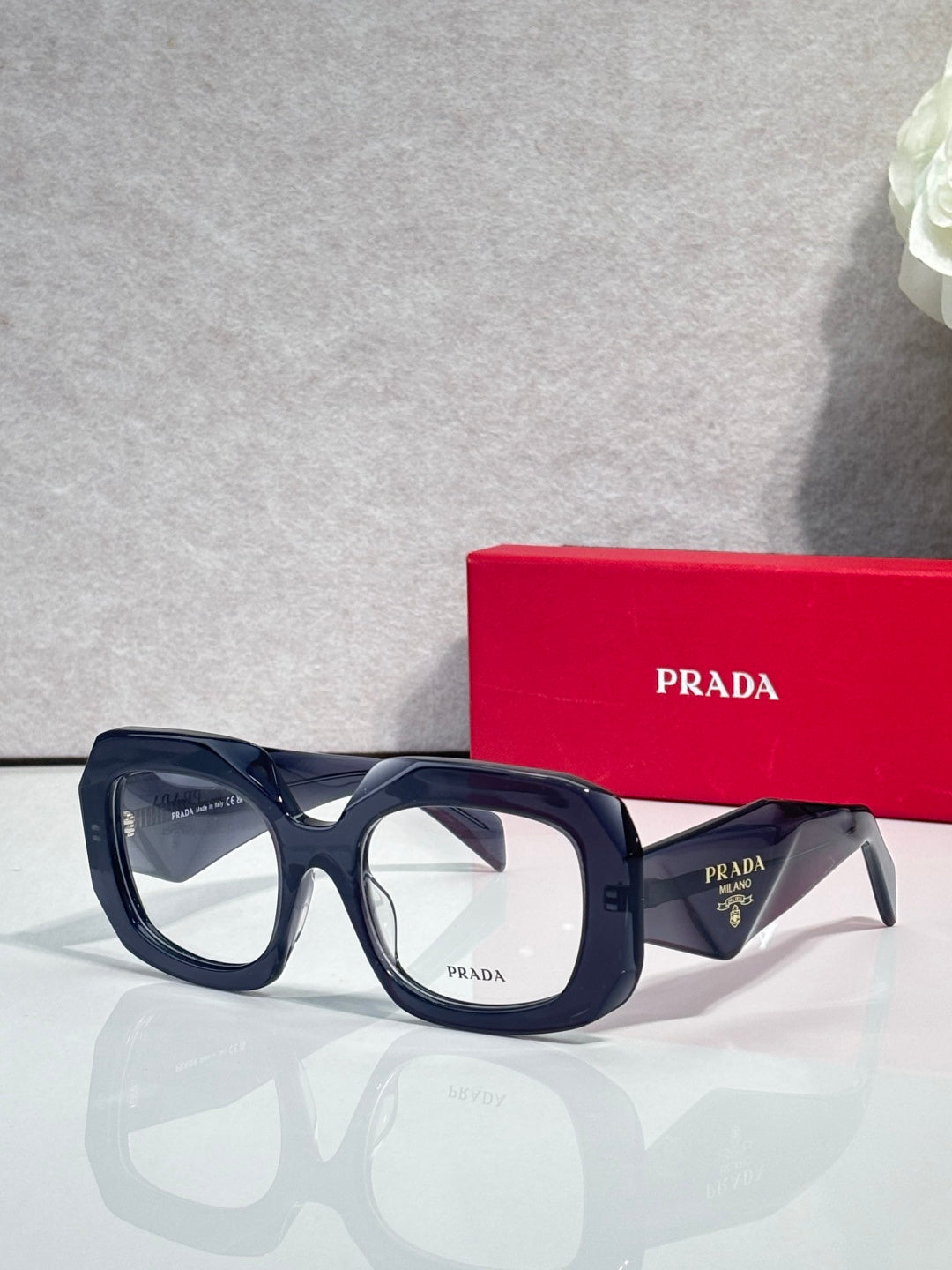 Prada eyeglasses with dark blue frames and clear lenses, side profile