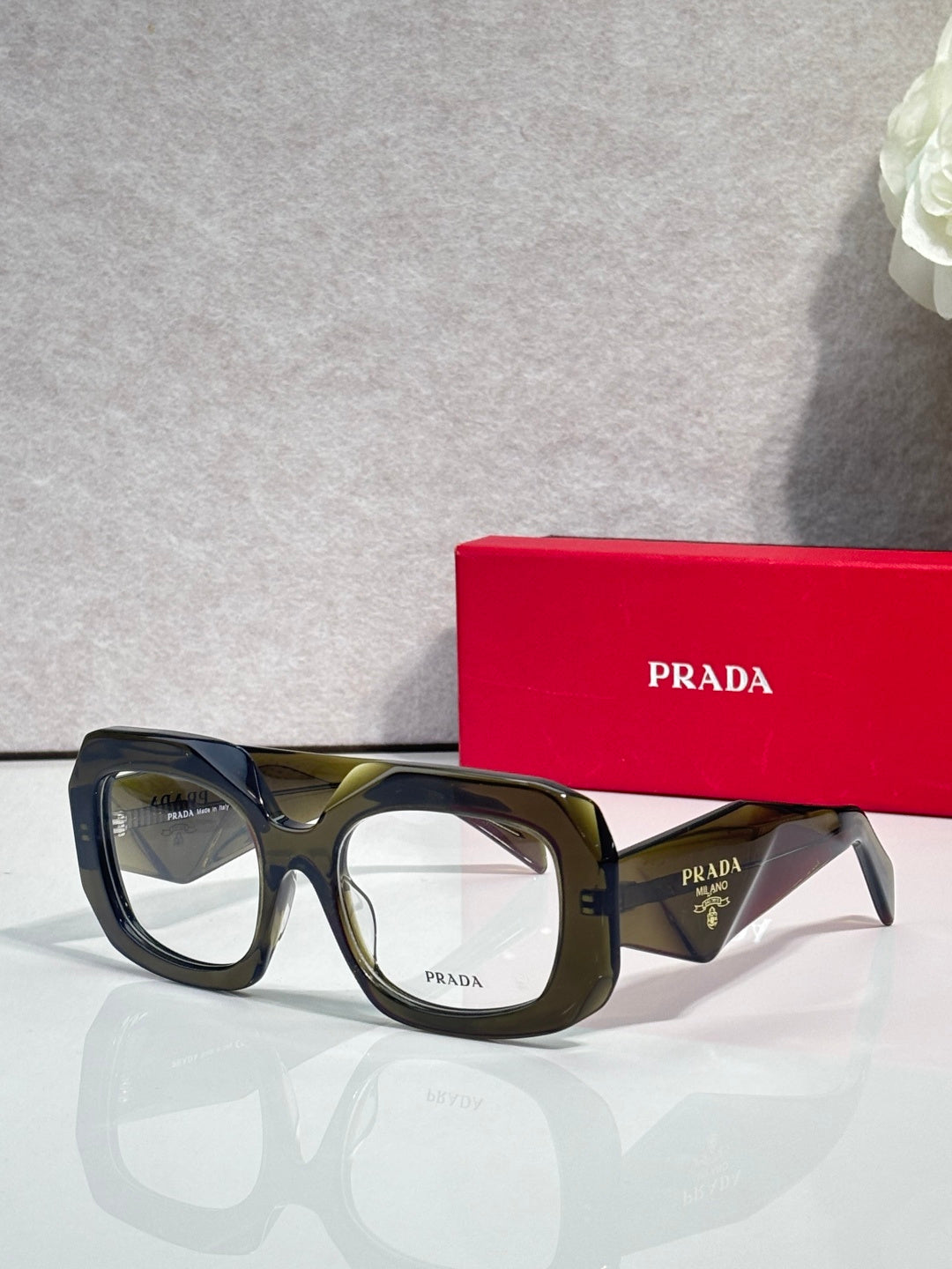 Prada eyeglasses with dark frames and clear lenses, green-tinted temple accents