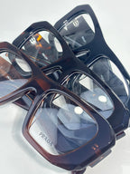Prada eyeglasses set with navy, brown, and tortoise rectangular frames, clear lenses
