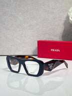 Prada black rectangular eyeglasses with clear lenses and tortoise top edge