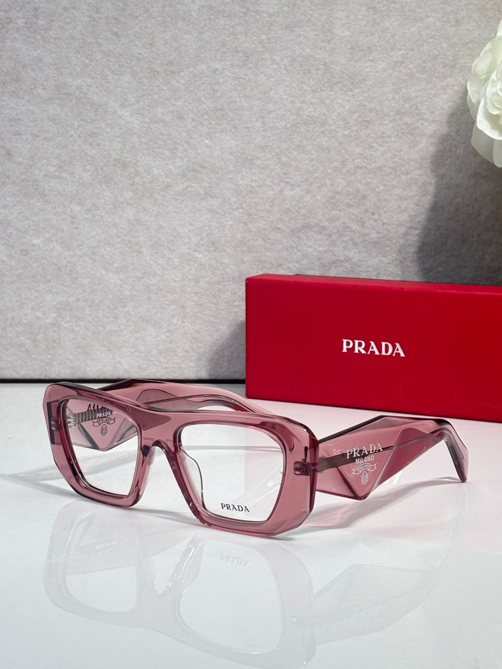 Prada burgundy rectangular eyeglasses with clear lenses and pink-tinted rims