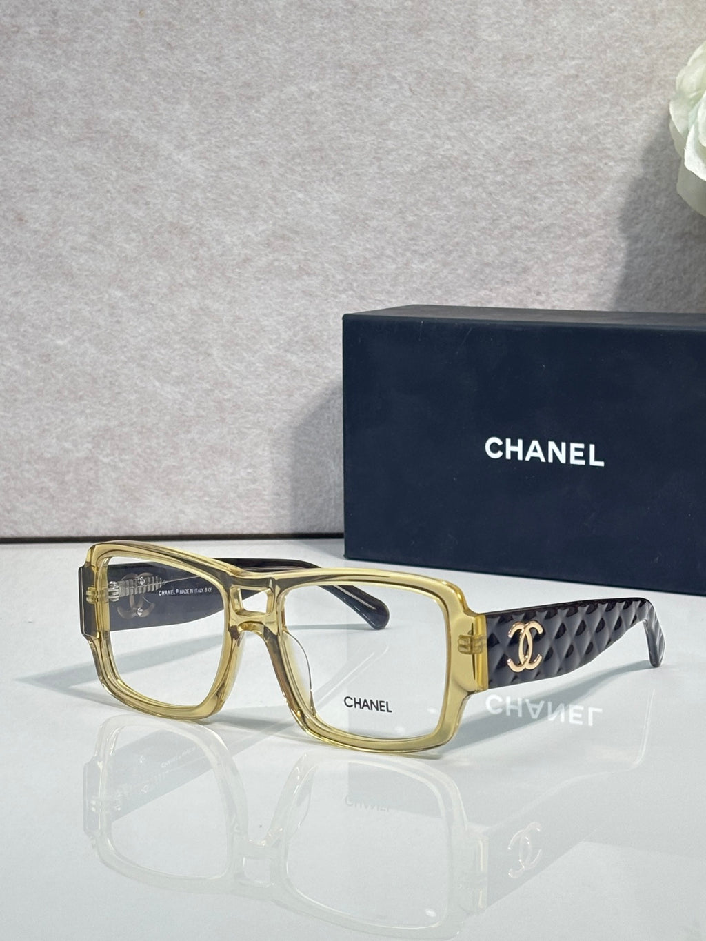 Gold rectangular eyeglasses with CHANEL logo and patterned temple arms