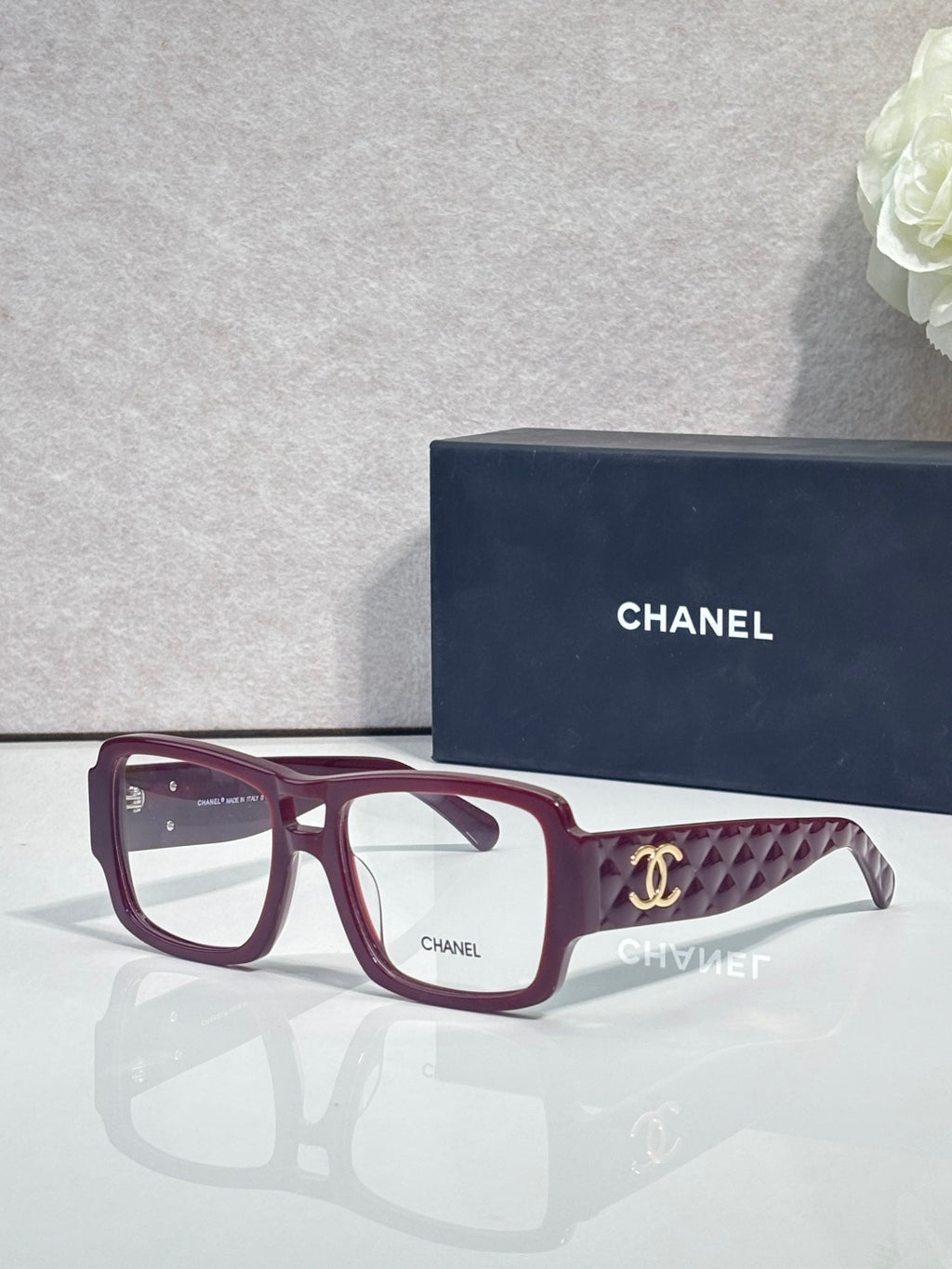 Burgundy rectangular eyeglasses with CHANEL logo and patterned temple arms