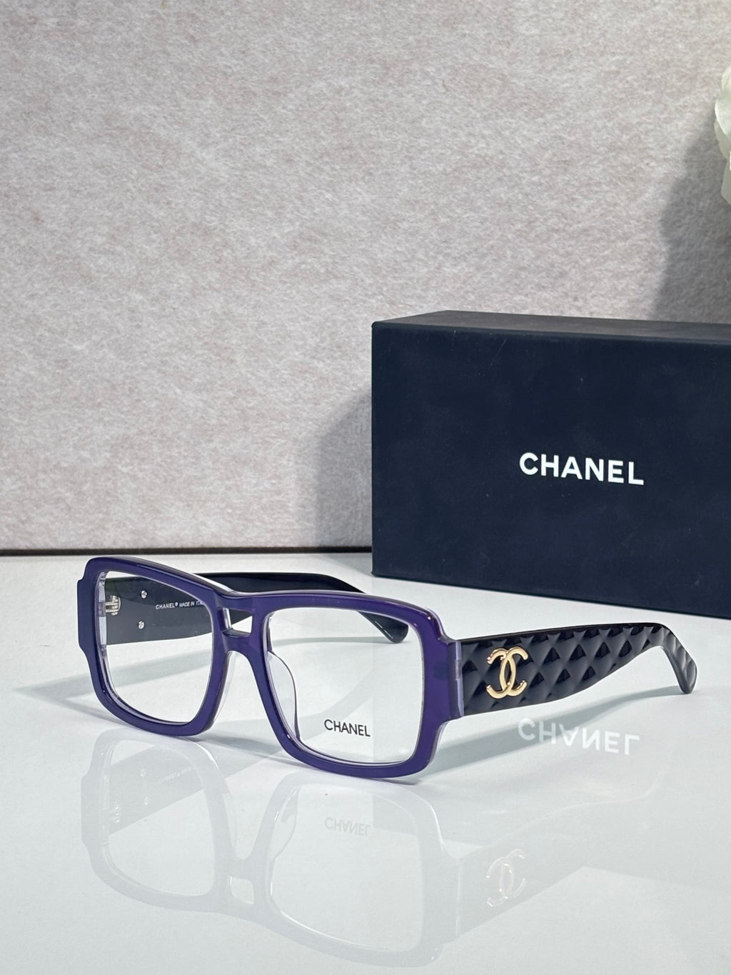 Blue rectangular eyeglasses with CHANEL logo and patterned temple arms