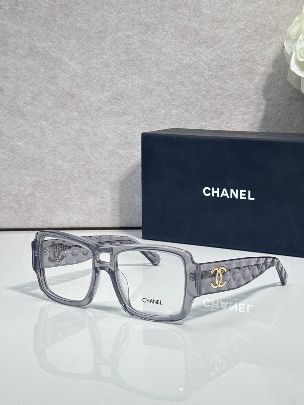 Clear rectangular eyeglasses with CHANEL logo and patterned temple arms