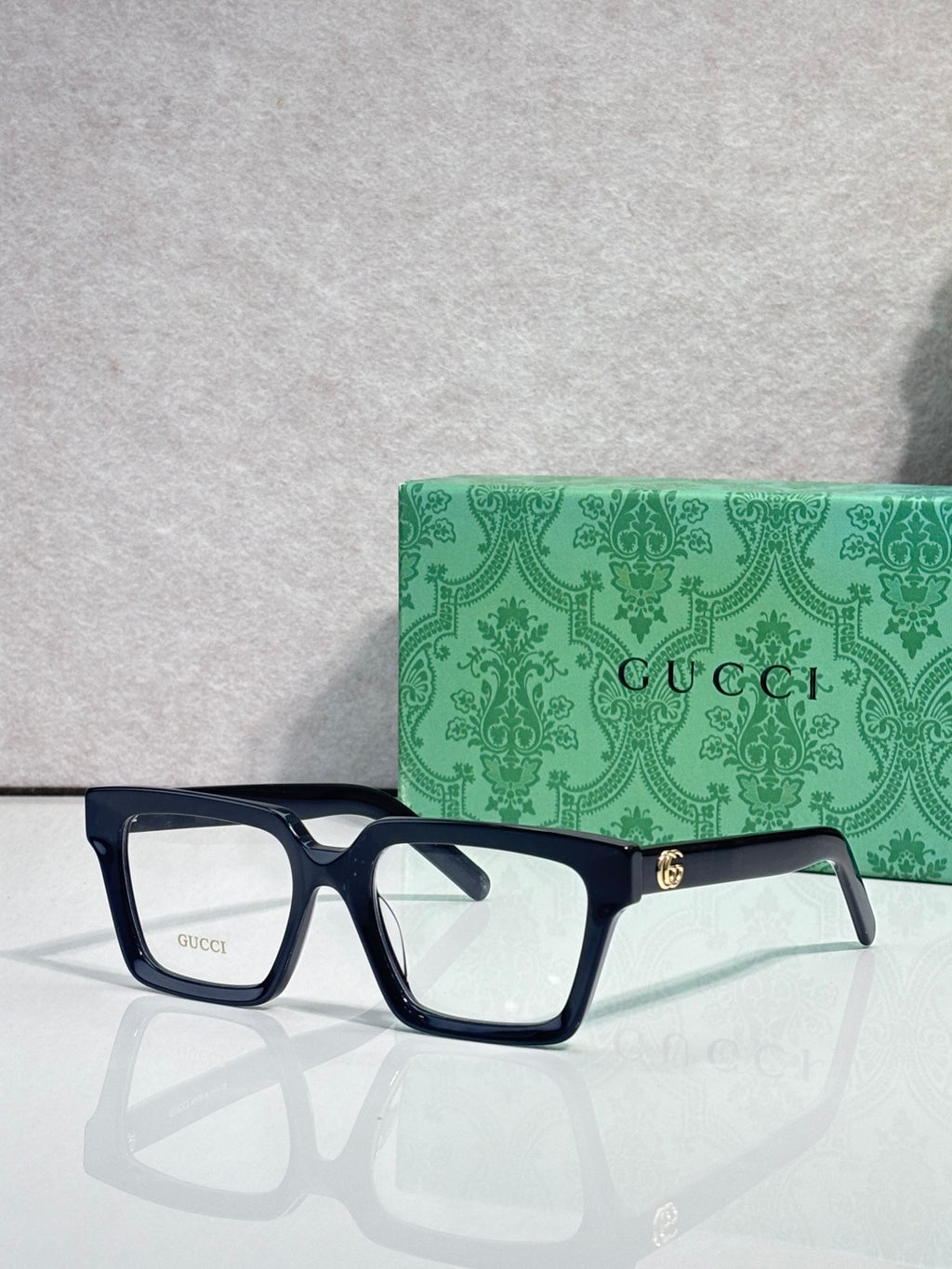 Gucci dark blue rectangular eyeglasses with clear lenses and gold hinge detail