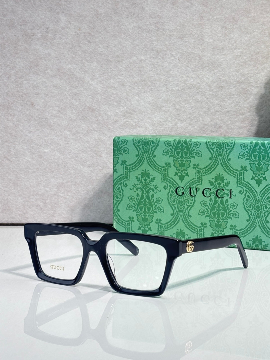 Gucci dark blue rectangular eyeglasses with clear lenses and gold hinge detail