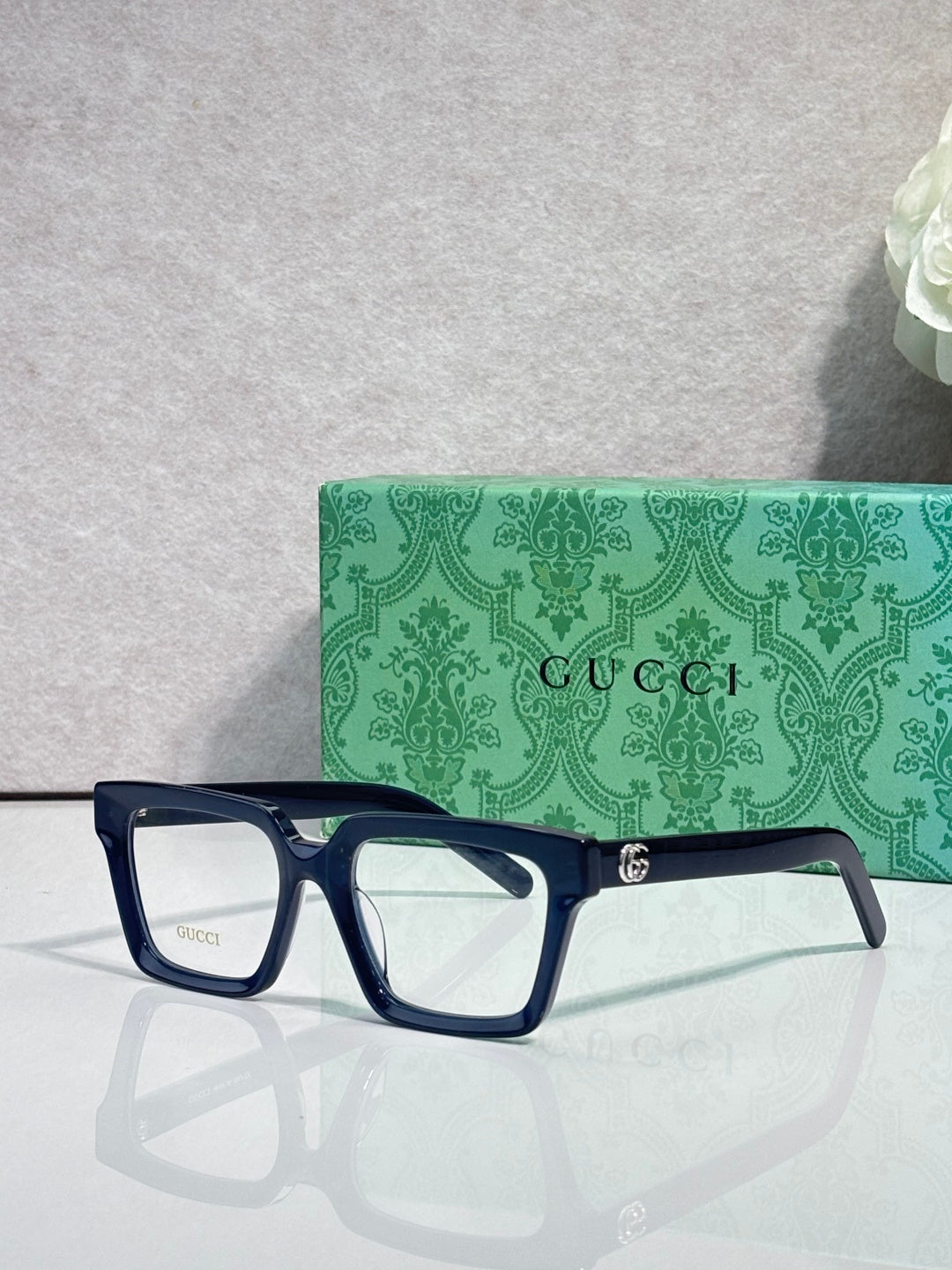 Gucci navy rectangular eyeglasses with clear lenses and gold logo on temple