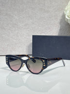 Sunglasses with dark blue frames, gold star accents, and gradient tinted lenses
