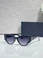 Sunglasses with dark blue cat-eye frames, gold star accents, and dark-tinted lenses