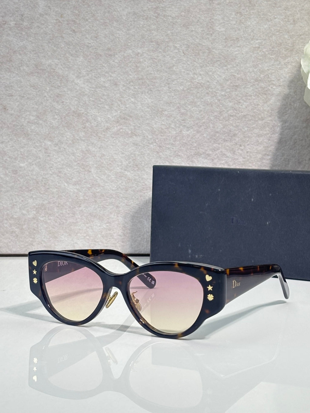 Dior sunglasses with dark blue frames, gold star detailing, and tinted lenses