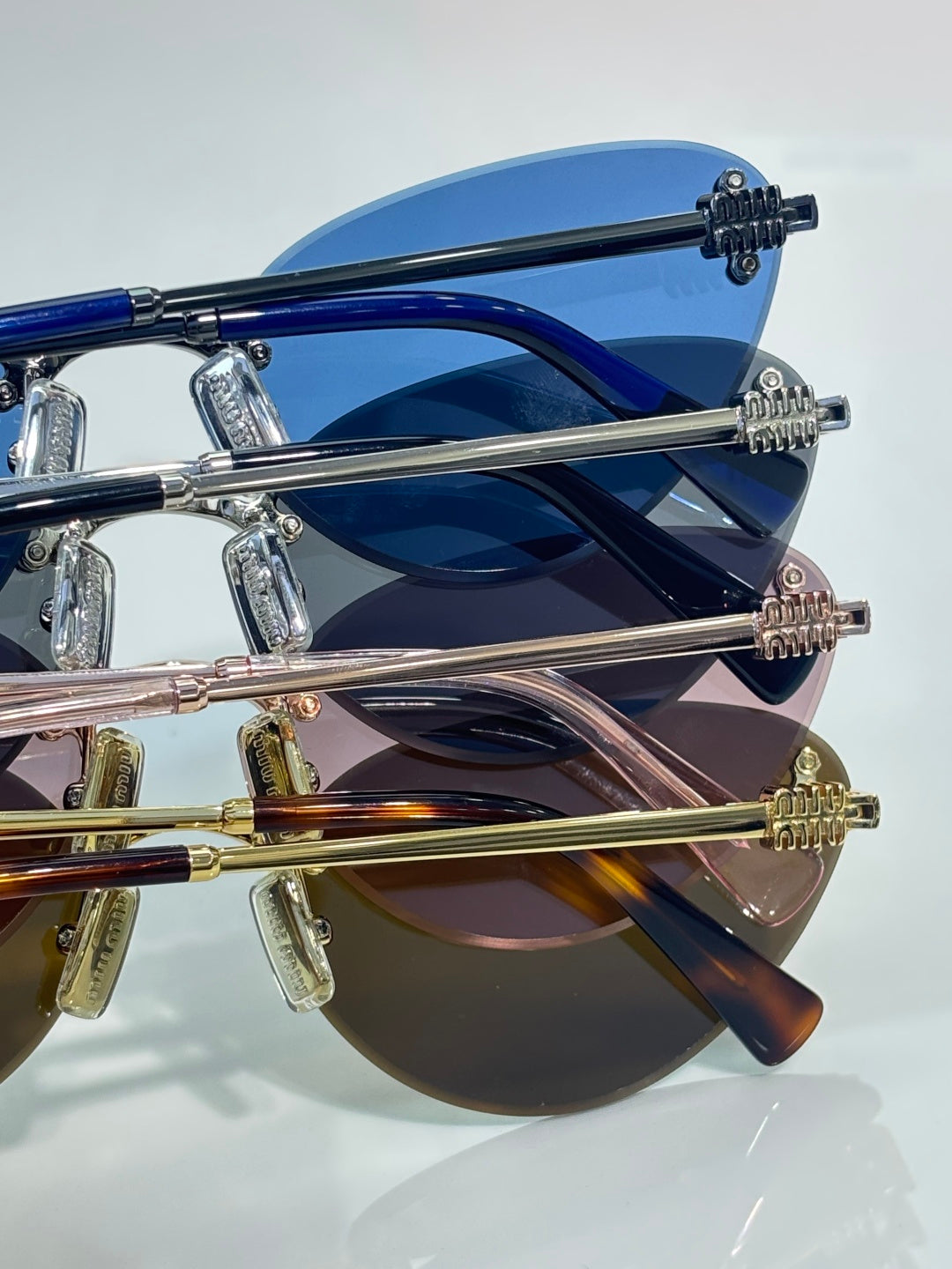 Sunglasses frame close-up showing blue, silver, and gold temple arms