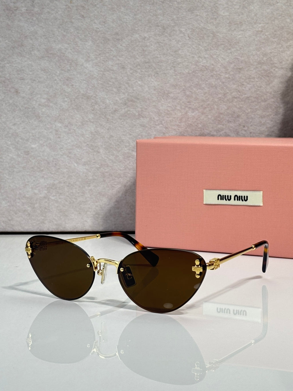 MiuMiu sunglasses with black round frames and dark brown tinted lenses
