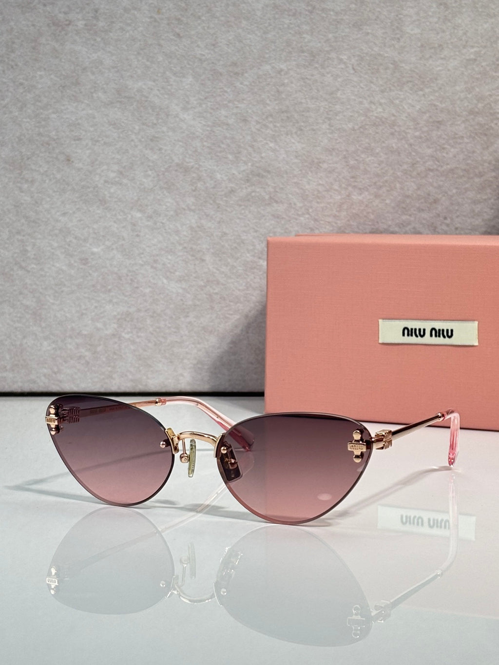 Sunglasses with gold round frames and mauve tinted lenses