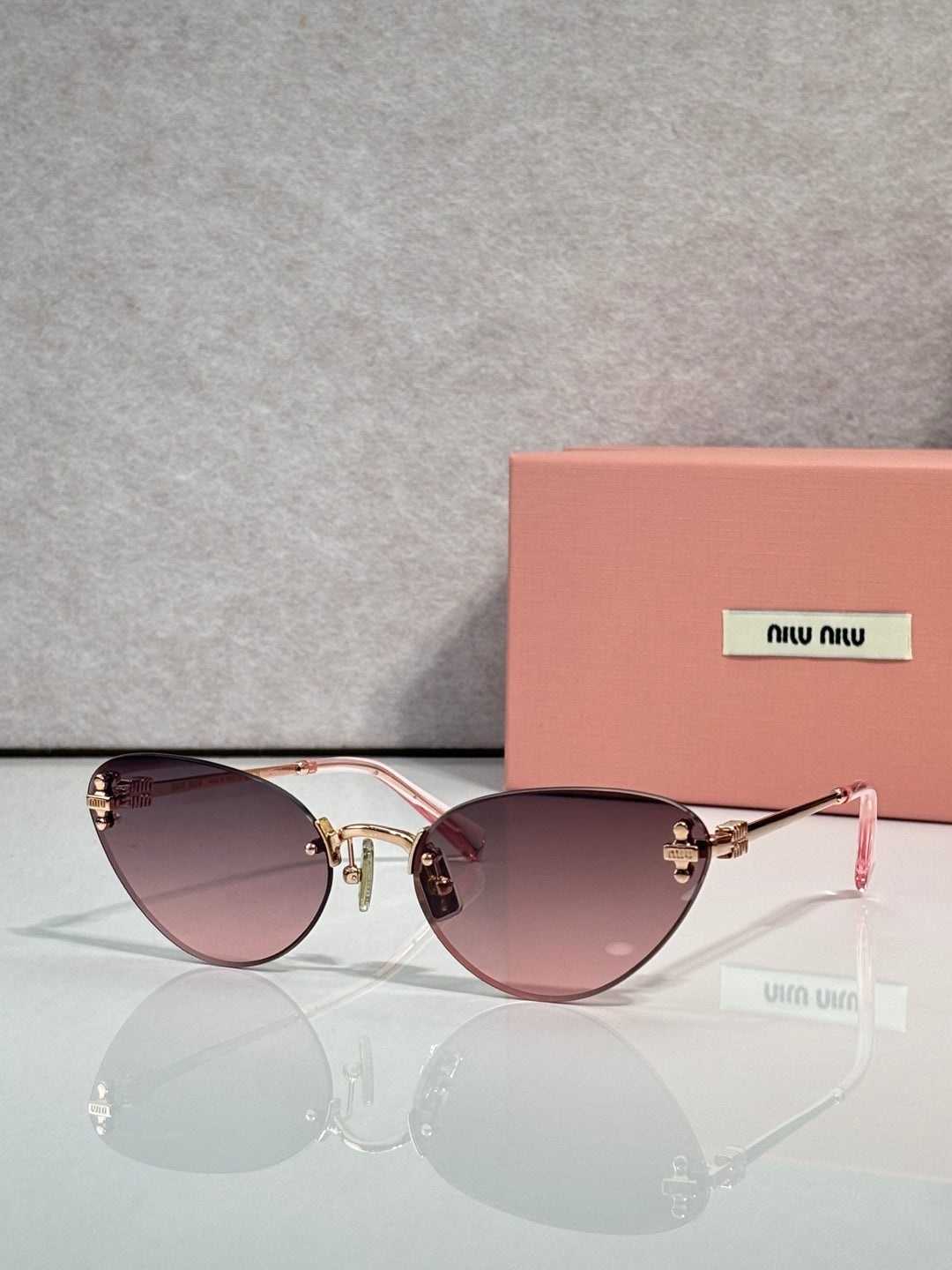 Sunglasses with gold round frames and mauve tinted lenses