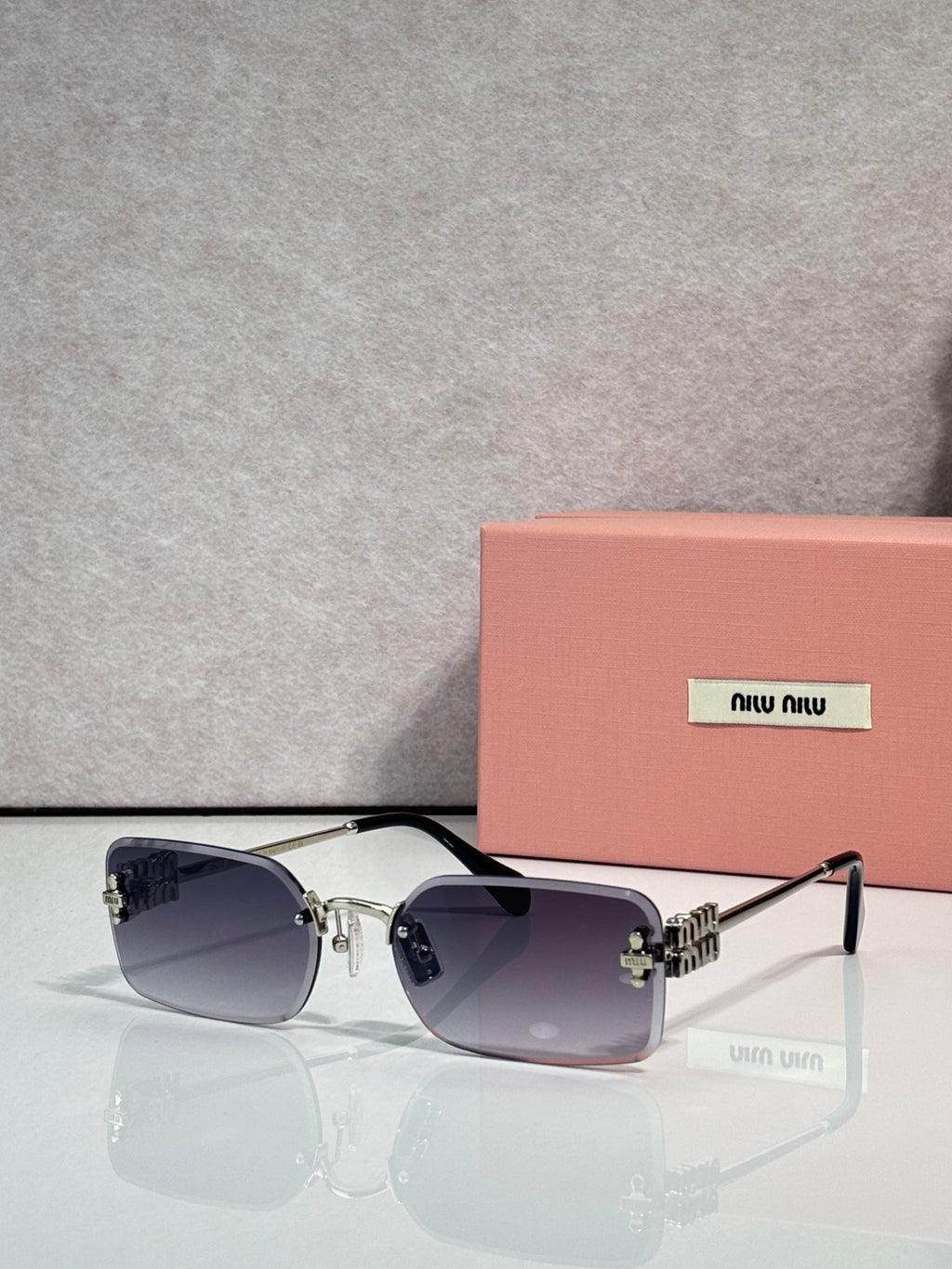 MiuMiu sunglasses with dark blue lenses, gold metal frame, thin black arms