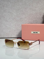 Sunglasses with brown-tinted lenses, gold frame, maroon accents on arms