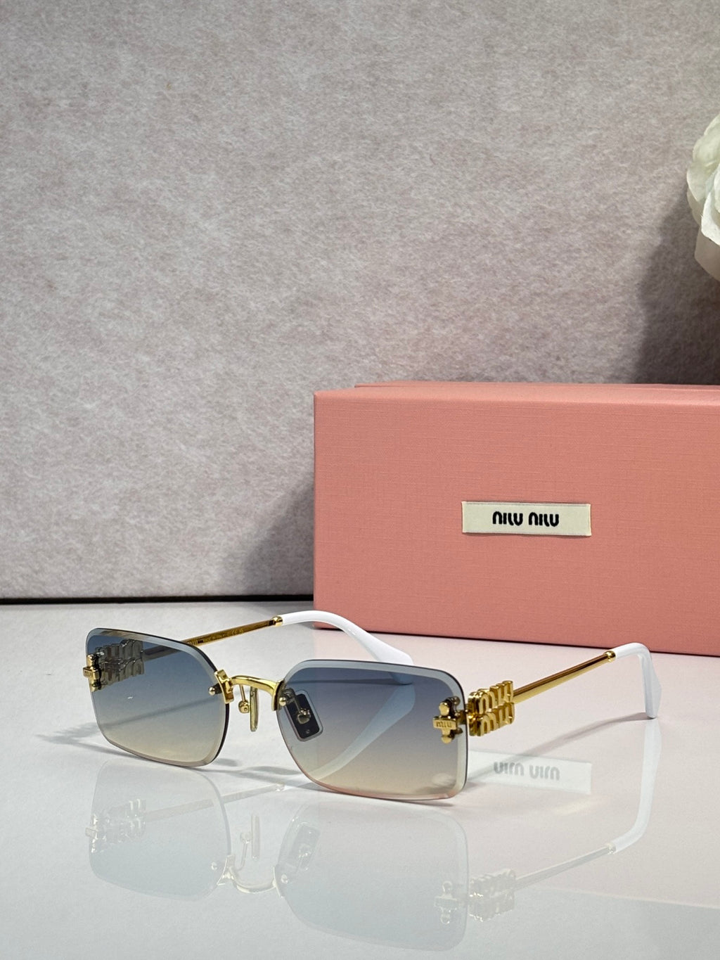 Sunglasses with light blue lenses, gold metal frame, black arms