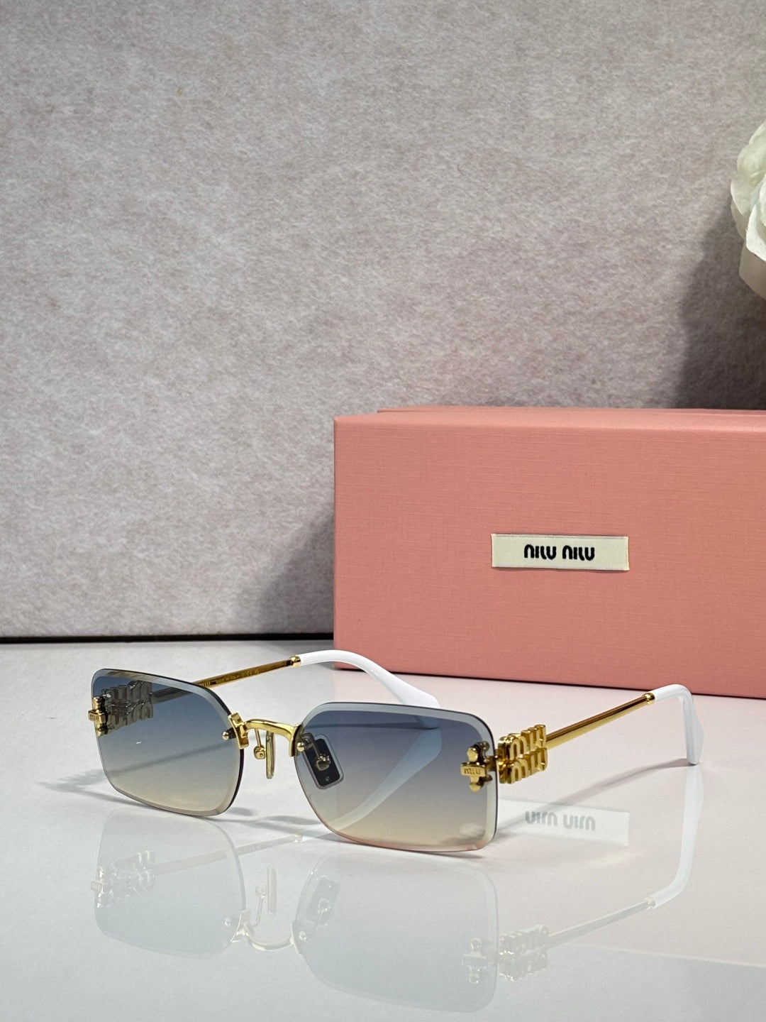 Sunglasses with light blue lenses, gold metal frame, black arms