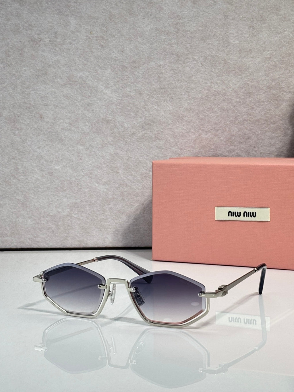 Gold-tone sunglasses with dark blue lenses and silver arms, rectangular cat-eye style.