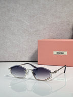 Gold-tone sunglasses with dark blue lenses and silver arms, rectangular cat-eye style.