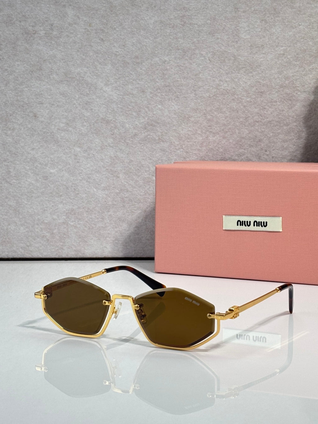 Gold-tone sunglasses with dark green lenses and brown-tinted arms, rectangular cat-eye style.