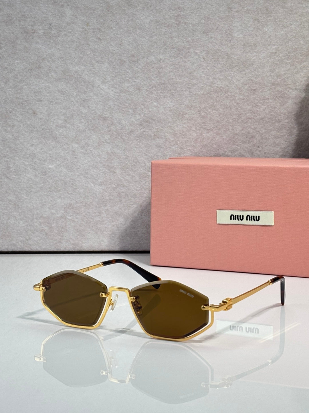 Gold-tone sunglasses with dark green lenses and brown-tinted arms, rectangular cat-eye style.