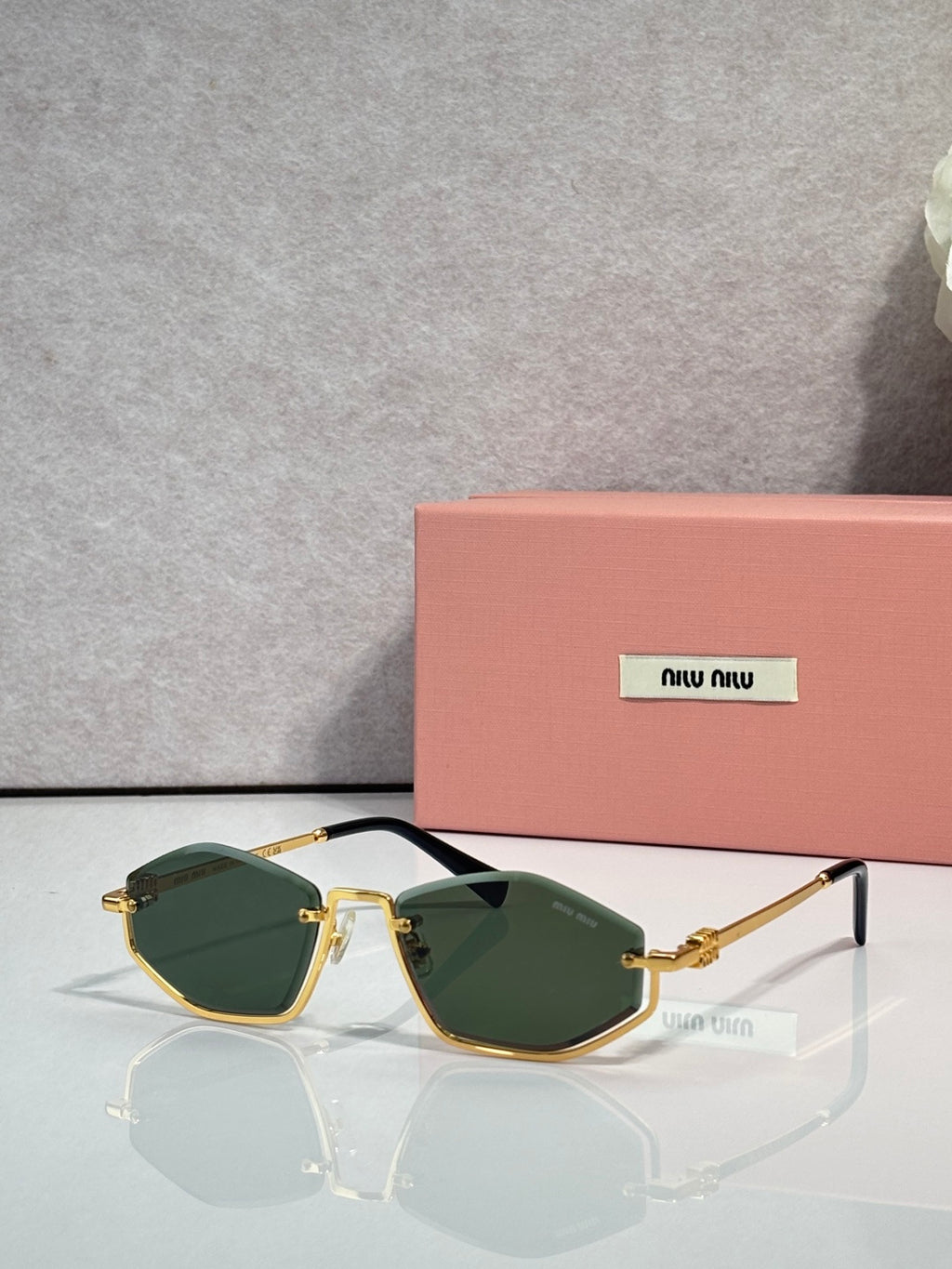 Gold-tone sunglasses with dark green lenses and thin metal arms, rectangular cat-eye style.