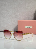 MiuMiu round sunglasses with gold frame, pink gradient lenses, and chain detail temples.