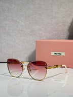 MiuMiu round sunglasses with gold frame, pink gradient lenses, and chain detail temples.
