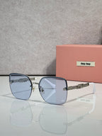 Sunglasses with light blue lenses, gold frame and chain temples, silver ear tips.