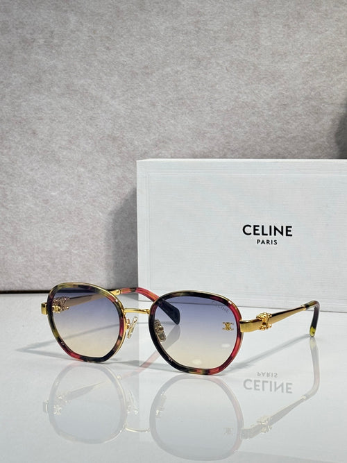 Round sunglasses with gold frame, dark lenses, and tortoise red temple accents