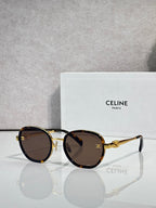 Round sunglasses with gold-tone frame, dark brown lenses, and gold hinges