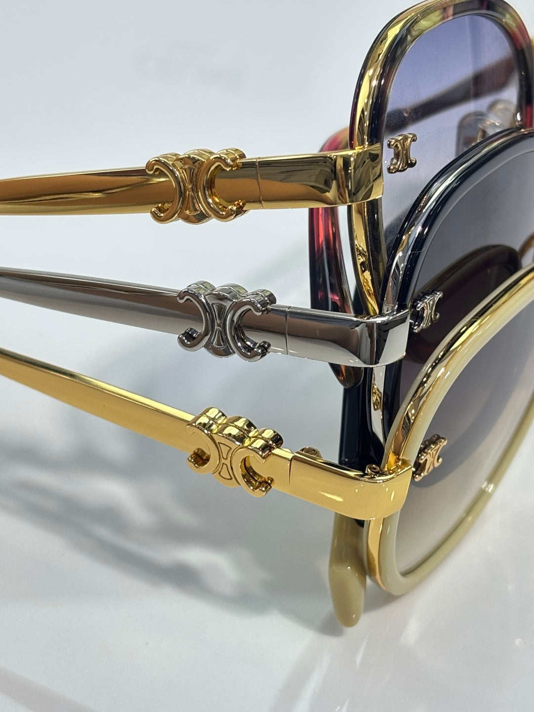 Close-up of gold and silver sunglass temple arms with decorative hardware