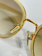 Close-up of gold sunglass temple with engraved logo on the earpiece