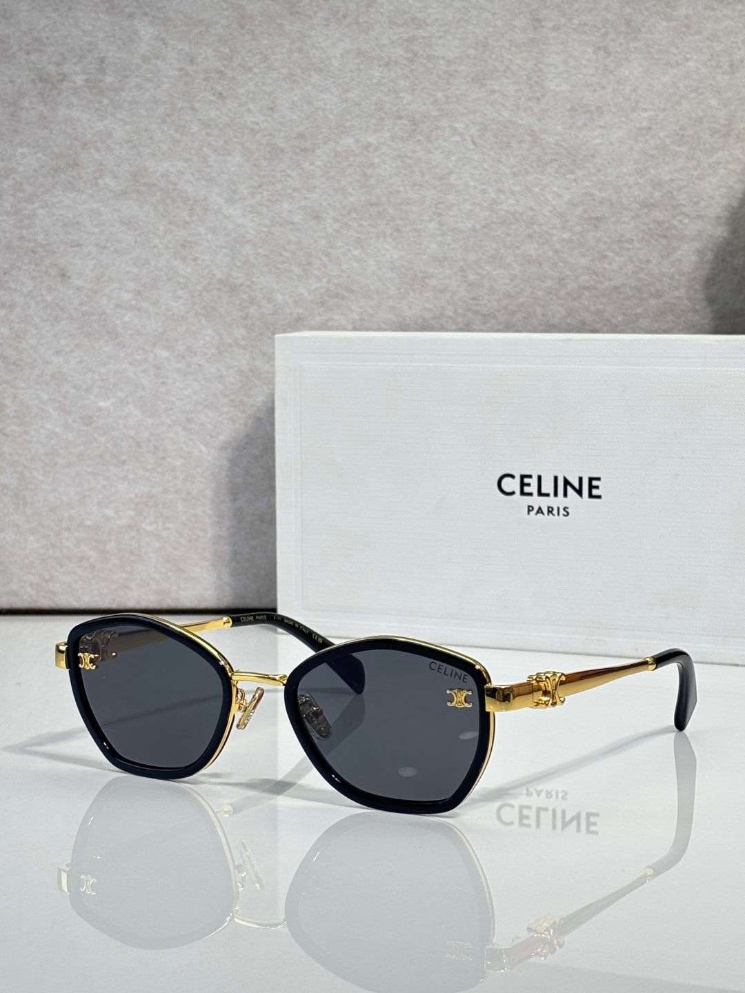 Celine sunglasses with round dark frames and smoky lenses, gold-tone accents