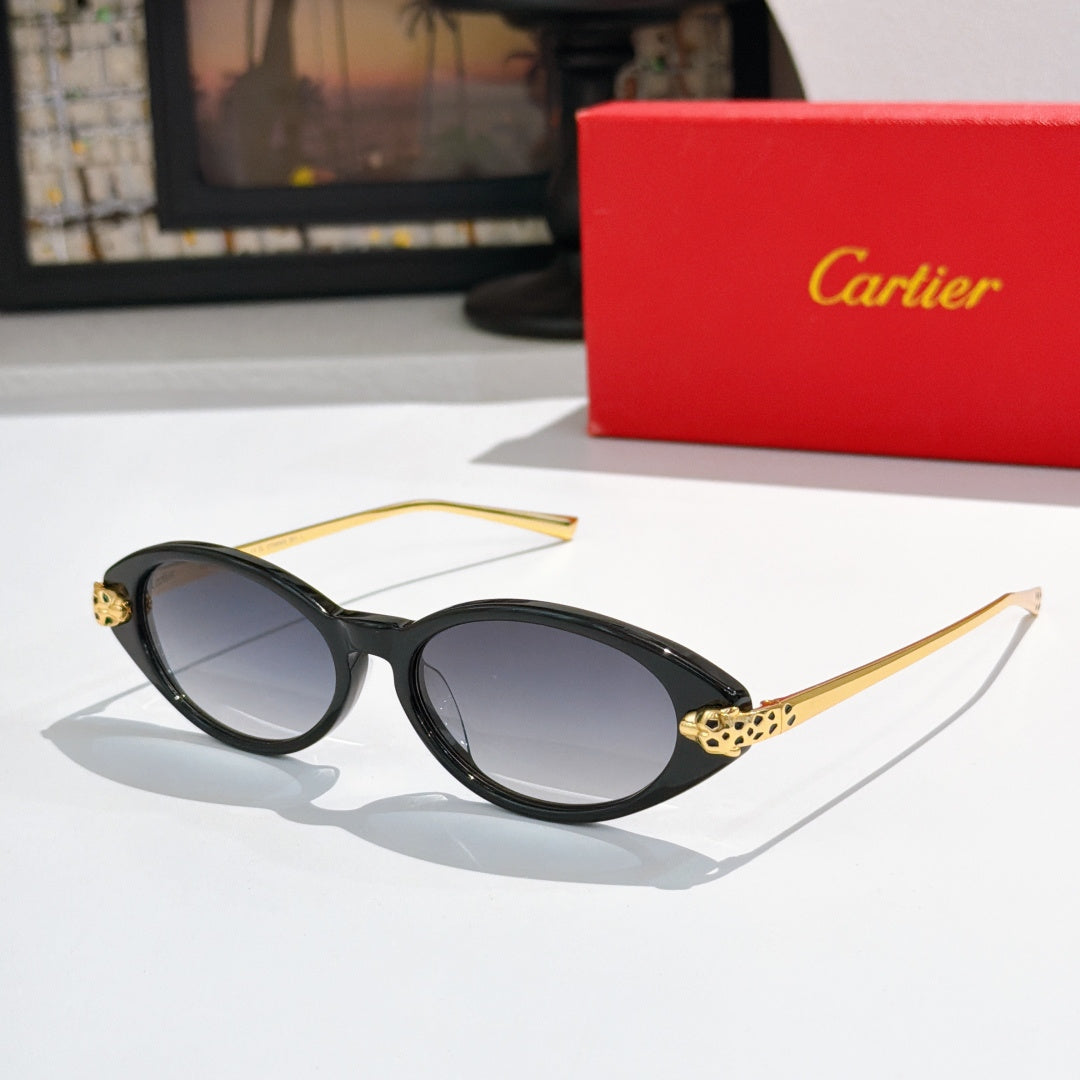 Black oval sunglasses with dark lenses and gold-tone stud accents