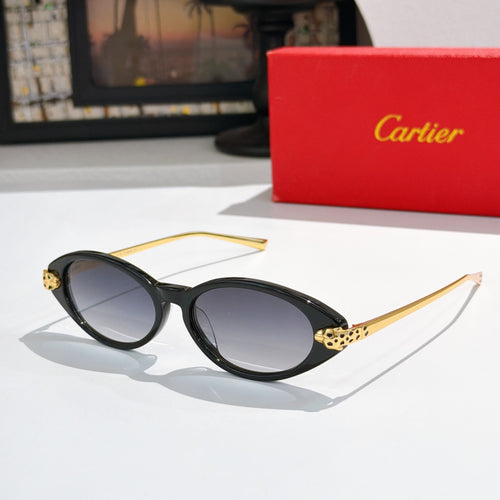 Black oval sunglasses with dark lenses and gold-tone stud accents