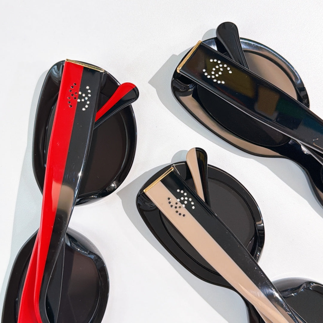 Assorted sunglasses, side angles on red, black, and tan frames with tinted lenses
