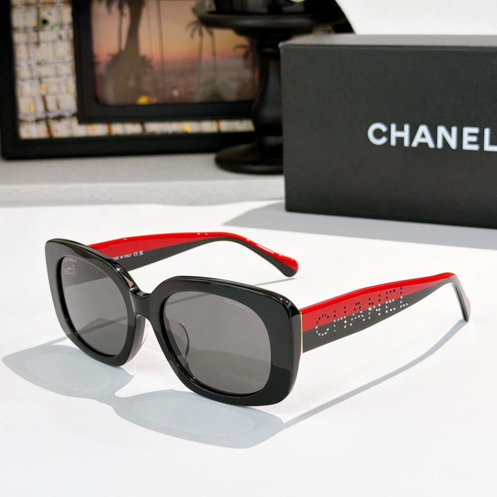 Black square sunglasses with gray tinted lenses, red side temples with logo