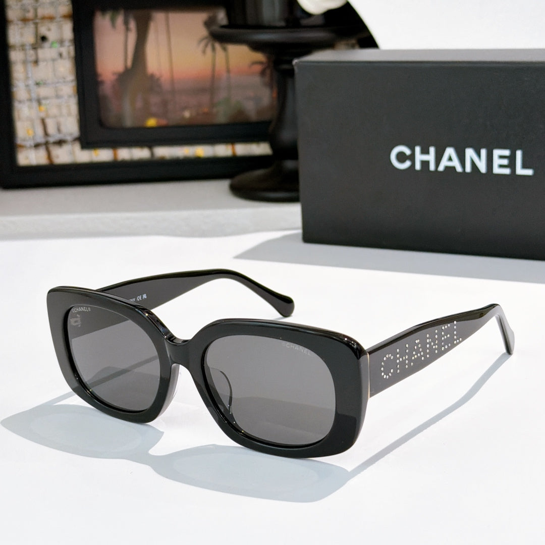 Black square sunglasses with gray tinted lenses, logo on side temples