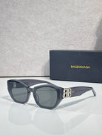 Sunglasses with dark blue frames, gray lenses, and gold B emblem
