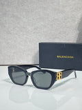 Sunglasses with dark blue frames, smoky lenses, and gold B emblem