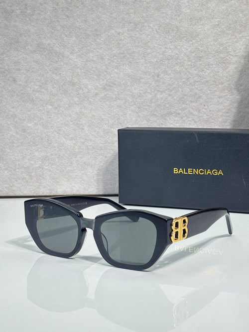 Sunglasses with dark blue frames, smoky lenses, and gold B emblem